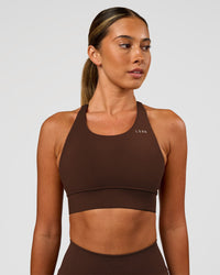 Woman wearing Accelerate Sports Bra - Hot Chocolate | Set:true | Angle:front | Model:Charli | Size:XS