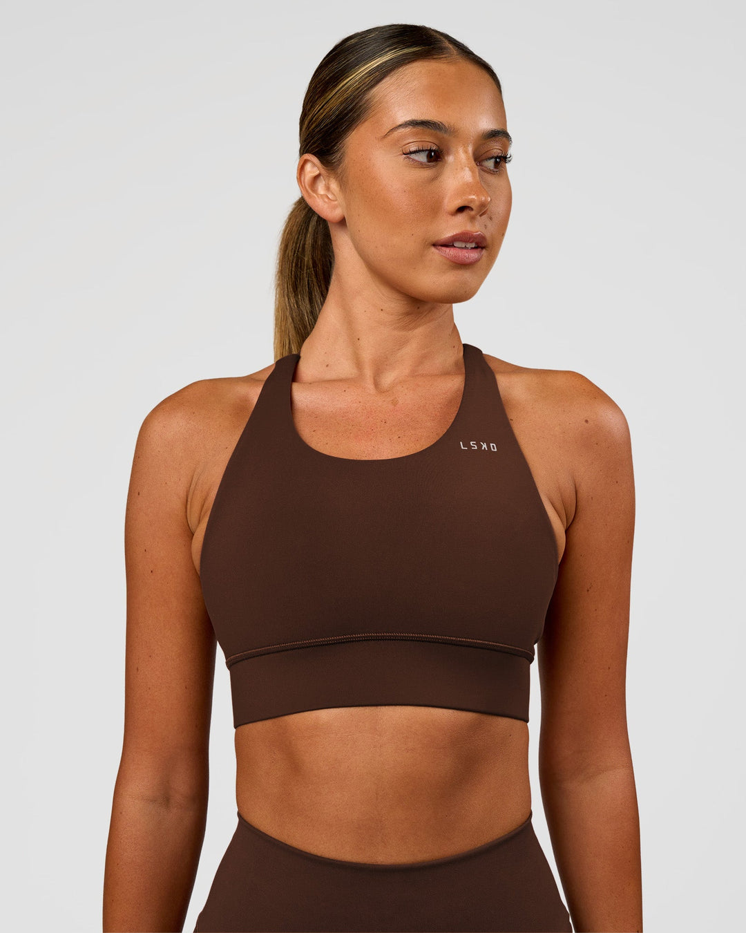 Woman wearing Accelerate Sports Bra - Hot Chocolate | Set:true | Angle:front | Model:Charli | Size:XS - view 3