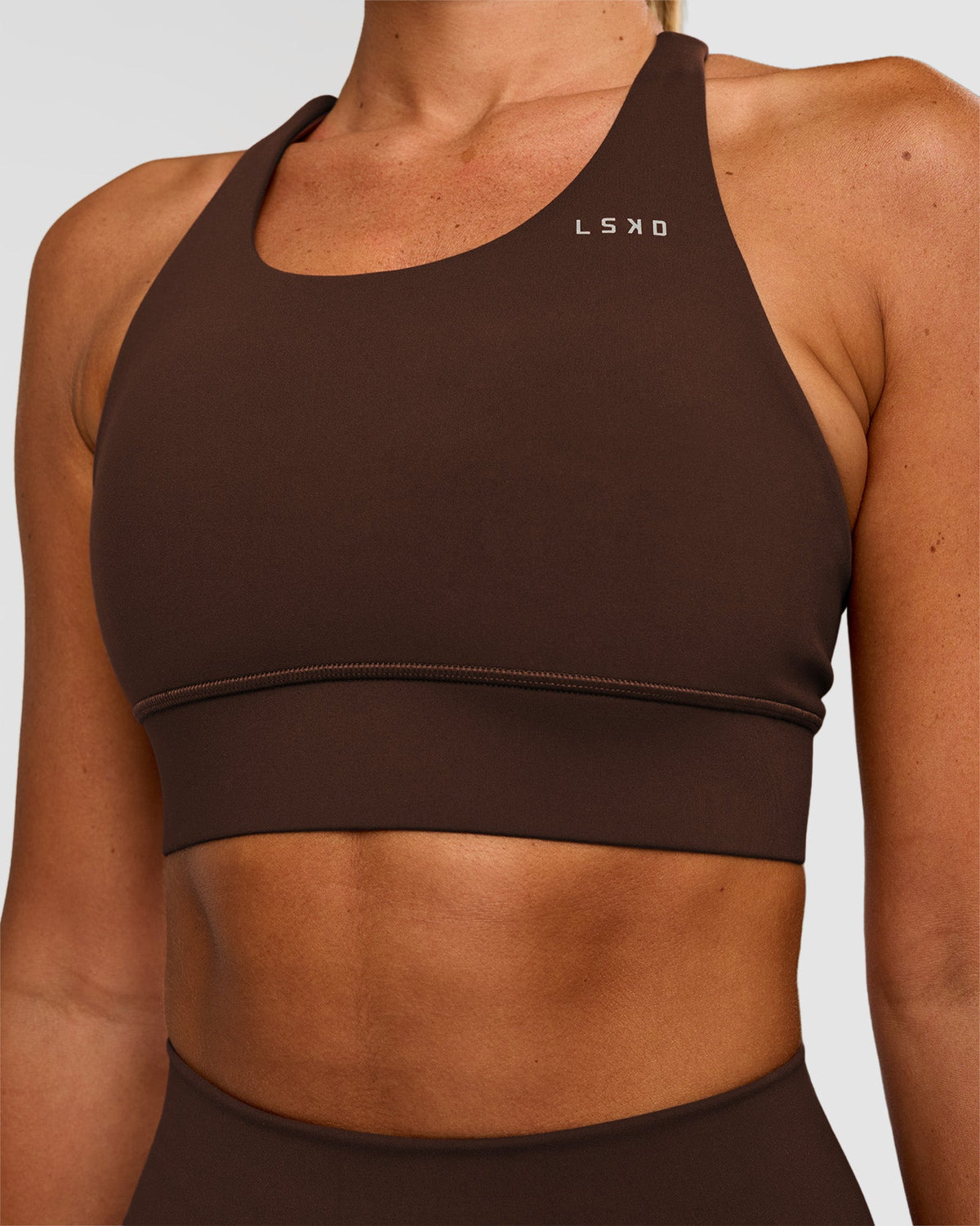 Woman wearing Accelerate Sports Bra - Hot Chocolate | Set:true | Angle:closeup | Model:Charli | Size:XS