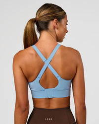 Woman wearing Accelerate Sports Bra - Open Air | Set:true | Angle:back | Model:Charli | Size:XS