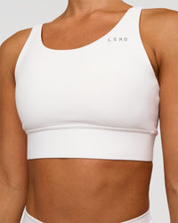Woman wearing Accelerate Sports Bra - White | Set:true | Angle:closeup | Model:Brylee | Size:XS | Thumbnail Index: 3