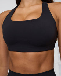 Woman wearing Aspire Sports Bra - Black | Model:Eliza | Size:XS