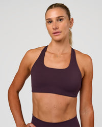 Woman wearing Aspire Sports Bra - Midnight Plum | Model:Emelia | Size:XS