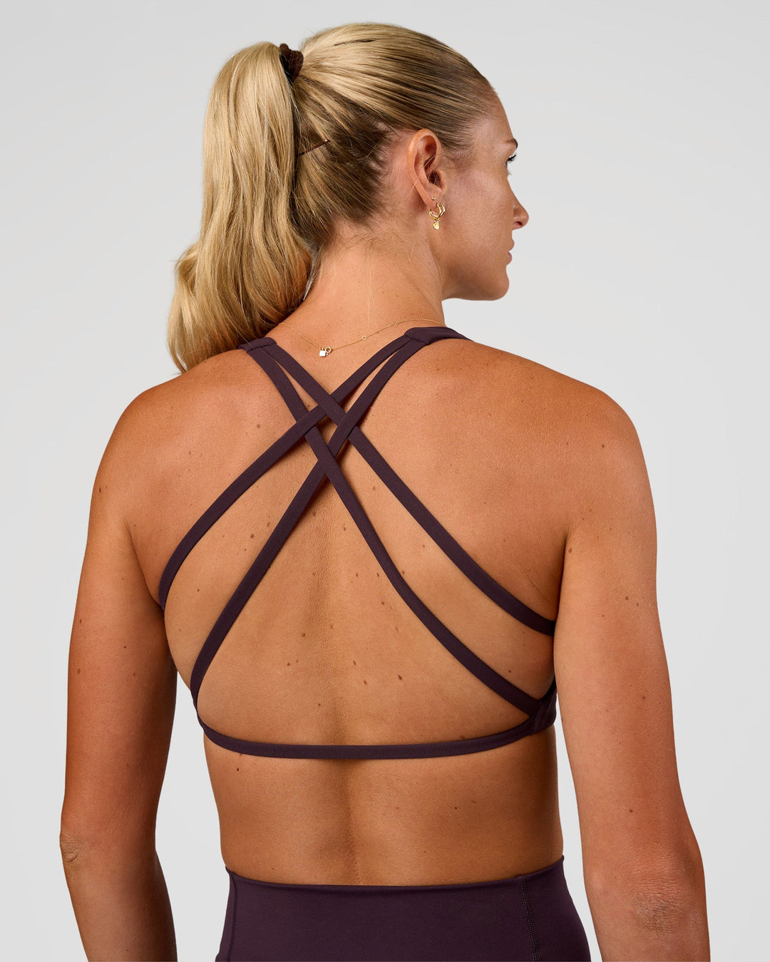Woman wearing Aspire Sports Bra - Midnight Plum | Model:Emelia | Size:XS