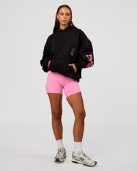 Woman wearing CFT BNE 26 Unisex Oversized Hoodie - Black-Candy Pink | Model:Brylee | Size:XS