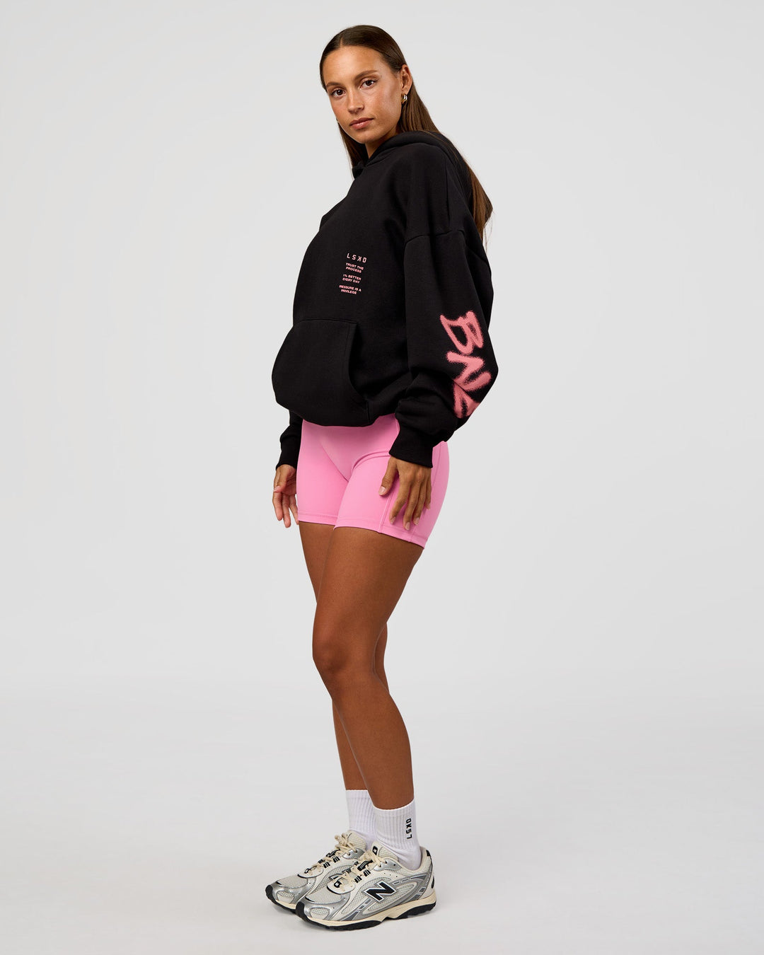 Woman wearing CFT BNE 26 Unisex Oversized Hoodie - Black-Candy Pink | Model:Brylee | Size:XS