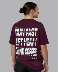 Woman wearing Coffee Run FLXCotton Oversized Tee - Cherry Lacquer-Black | Model:Sav | Size:XS