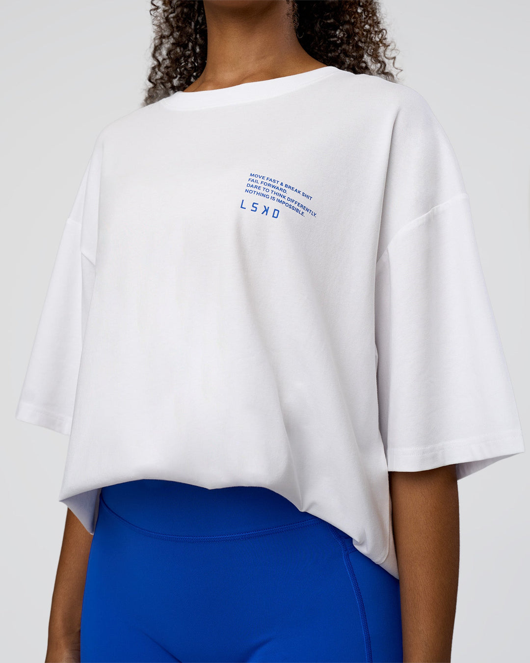 Woman wearing Coffee Run FLXCotton Oversized Tee - White-Electric Indigo | Model:Jordan | Size:L