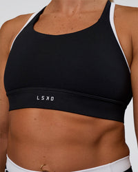 Woman wearing Distinction Sports Bra 2.0 - Black-White | Model:Sav | Size:XS