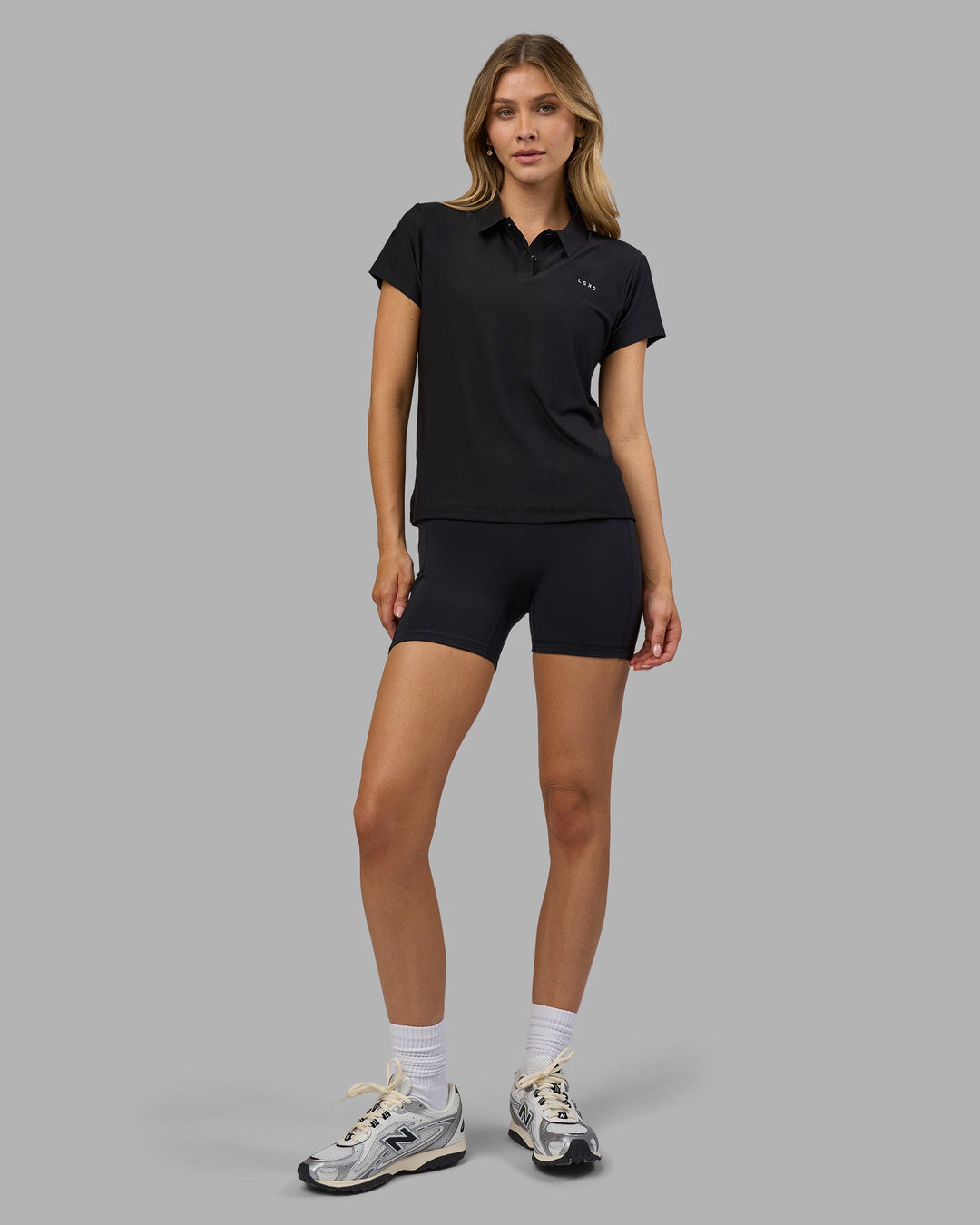 Woman wearing Drive Polo - Black | Model:Leilani| Size:XS