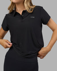 Woman wearing Drive Polo - Black | Model:Leilani| Size:XS | Thumbnail Index: 1