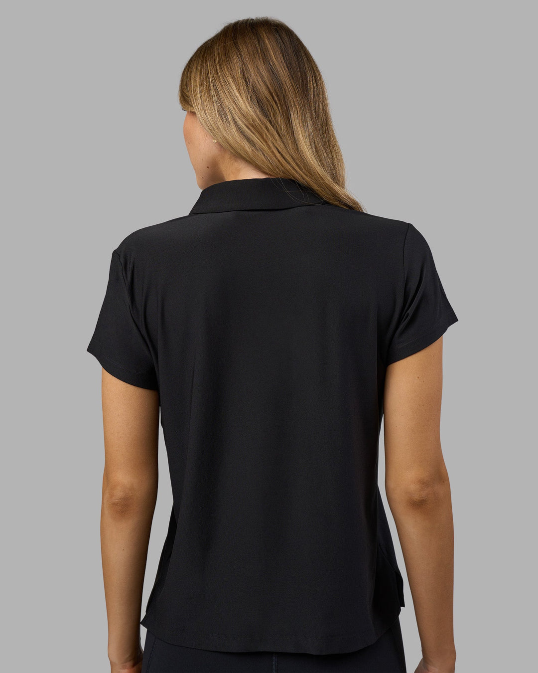 Woman wearing Drive Polo - Black | Model:Leilani| Size:XS