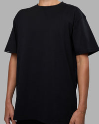 Woman wearing Easy FLXCotton Tee Oversize - Black | Model:Katie | Size:XS