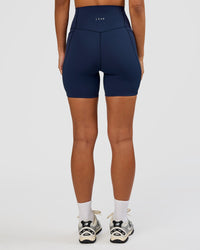 Woman wearing Elixir Ultra High-Rise 6” Short Pockets - Future Navy | Model:Brylee | Size:XS