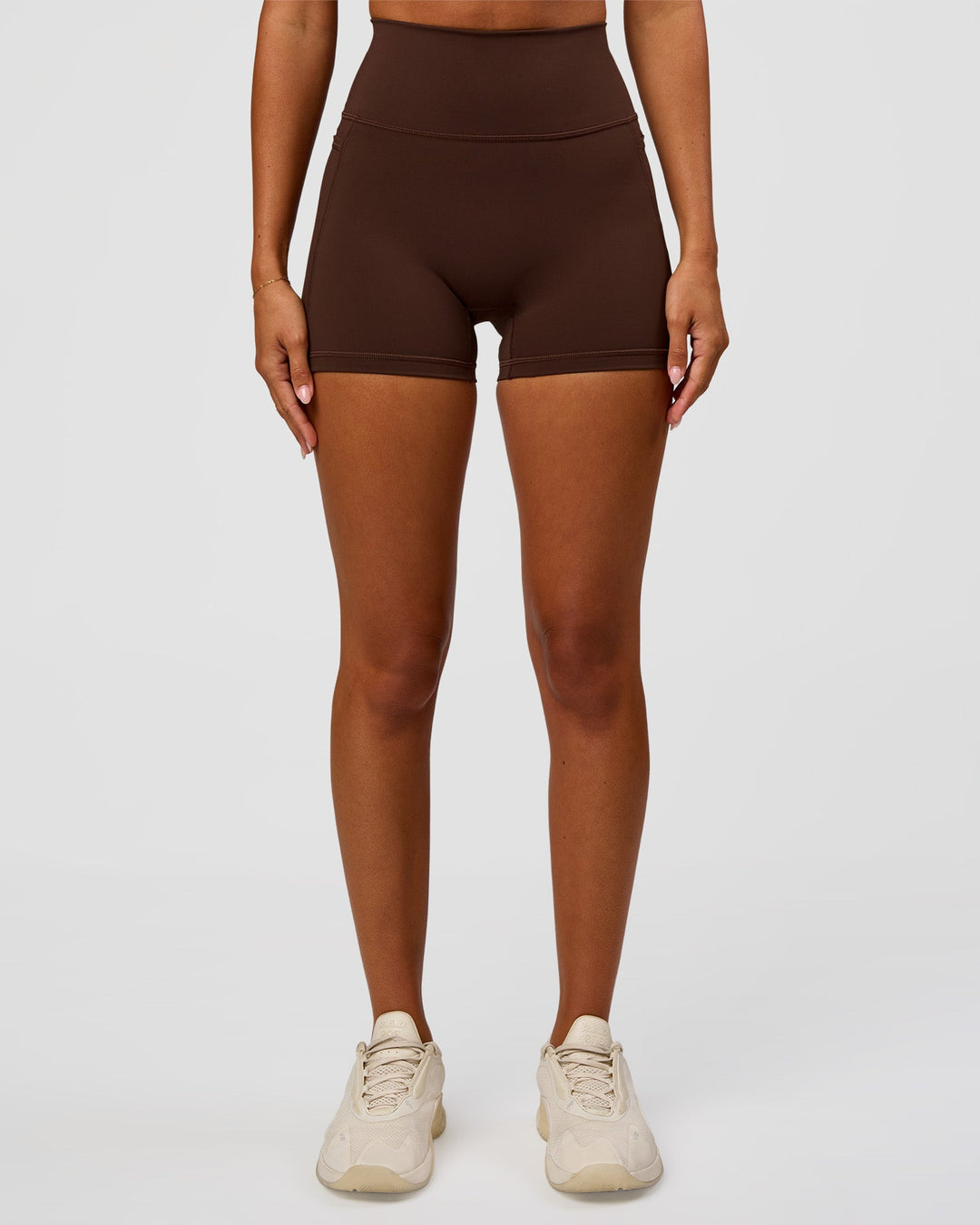 Woman wearing Fusion Ultra High-Rise 4" Short Pockets - Hot Chocolate | Set:true | Angle:front | Model:Charli | Size:XS