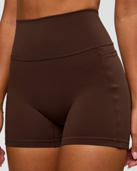 Woman wearing Fusion Ultra High-Rise 4" Short Pockets - Hot Chocolate | Model:Charli | Size:XS