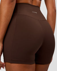 Woman wearing Fusion Ultra High-Rise 4" Short Pockets - Hot Chocolate | Model:Charli | Size:XS