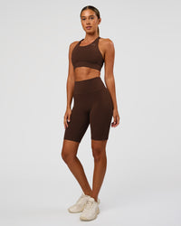 Woman wearing Fusion Ultra High-Rise 9" Short Pockets - Hot Chocolate | Model:Charli | Size:XS