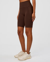 Woman wearing Fusion Ultra High-Rise 9" Short Pockets - Hot Chocolate | Model:Charli | Size:XS