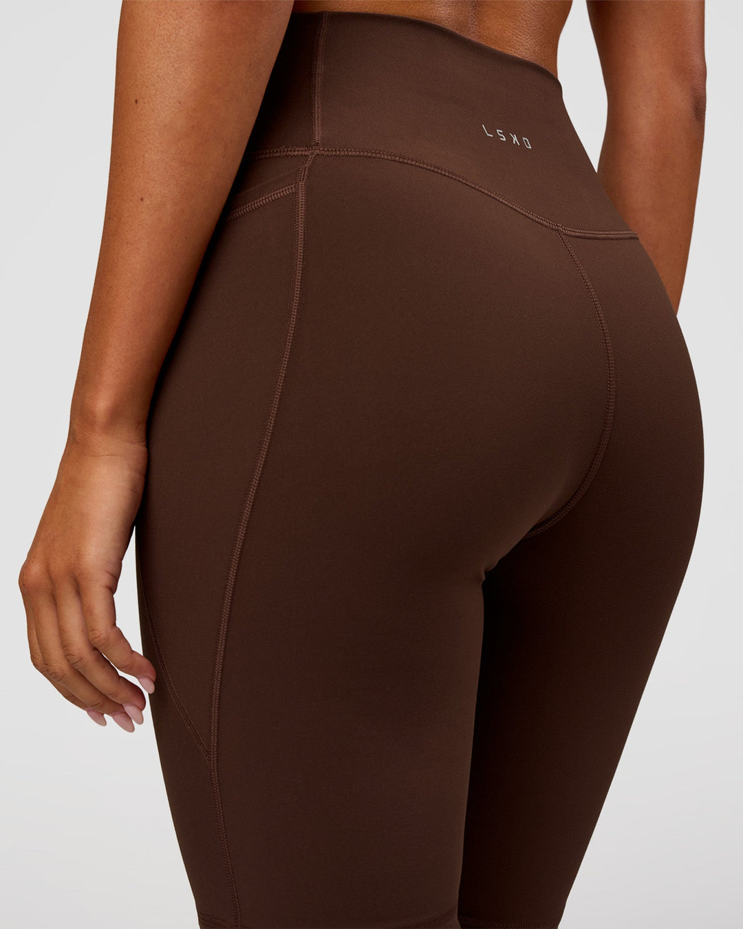 Woman wearing Fusion Ultra High-Rise 9" Short Pockets - Hot Chocolate | Model:Charli | Size:XS