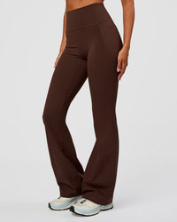 Woman wearing Fusion Ultra High-Rise Flared Legging Pockets - Hot Chocolate | Model:Charli | Size:XS | Thumbnail Index: 0