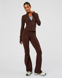 Woman wearing Fusion Ultra High-Rise Flared Legging Pockets - Hot Chocolate | Model:Charli | Size:XS | Thumbnail Index: 1