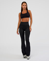 Woman wearing Fusion Ultra High-Rise Flared Petite Legging Pockets - Black | Model:Brylee | Size:XS