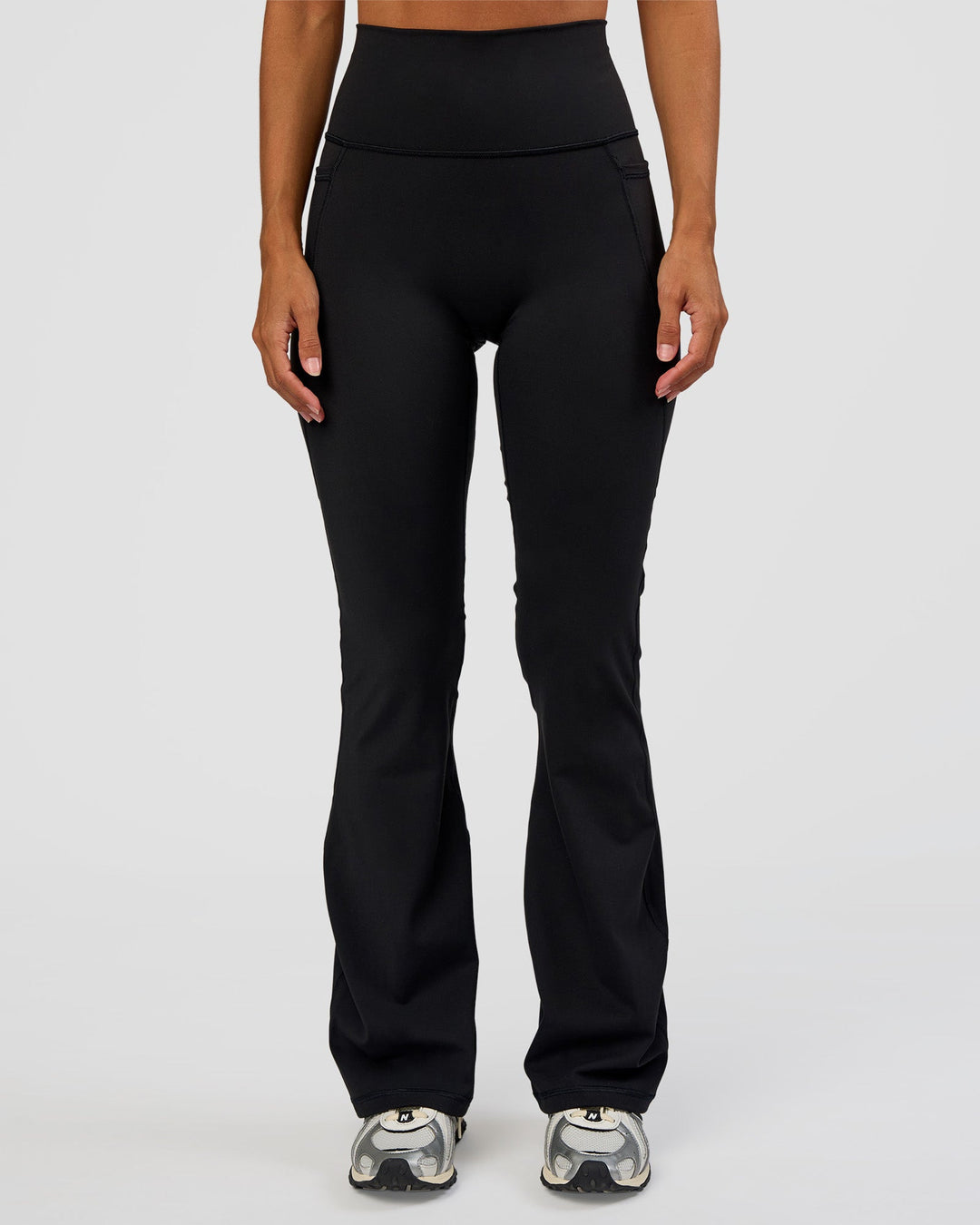 Woman wearing Fusion Ultra High-Rise Flared Petite Legging Pockets - Black | Model:Brylee | Size:XS