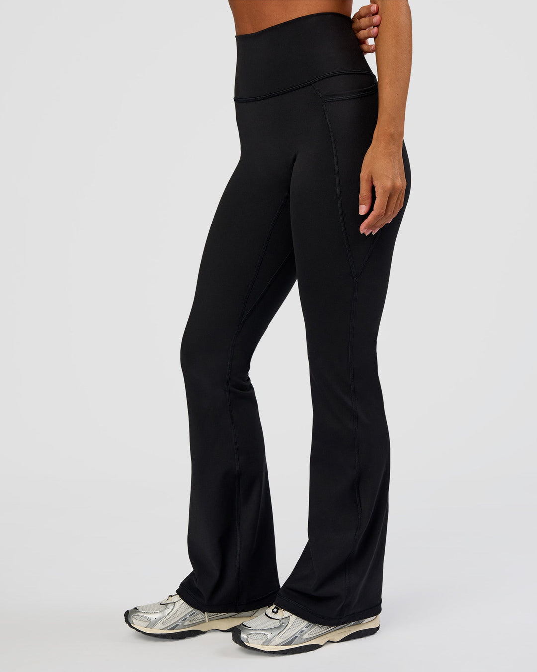 Woman wearing Fusion Ultra High-Rise Flared Petite Legging Pockets - Black | Model:Brylee | Size:XS