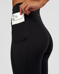Woman wearing Fusion Ultra High-Rise Flared Petite Legging Pockets - Black | Model:Brylee | Size:XS