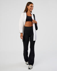 Woman wearing Fusion Ultra High-Rise Flared Petite Legging Pockets - Black | Model:Brylee | Size:XS