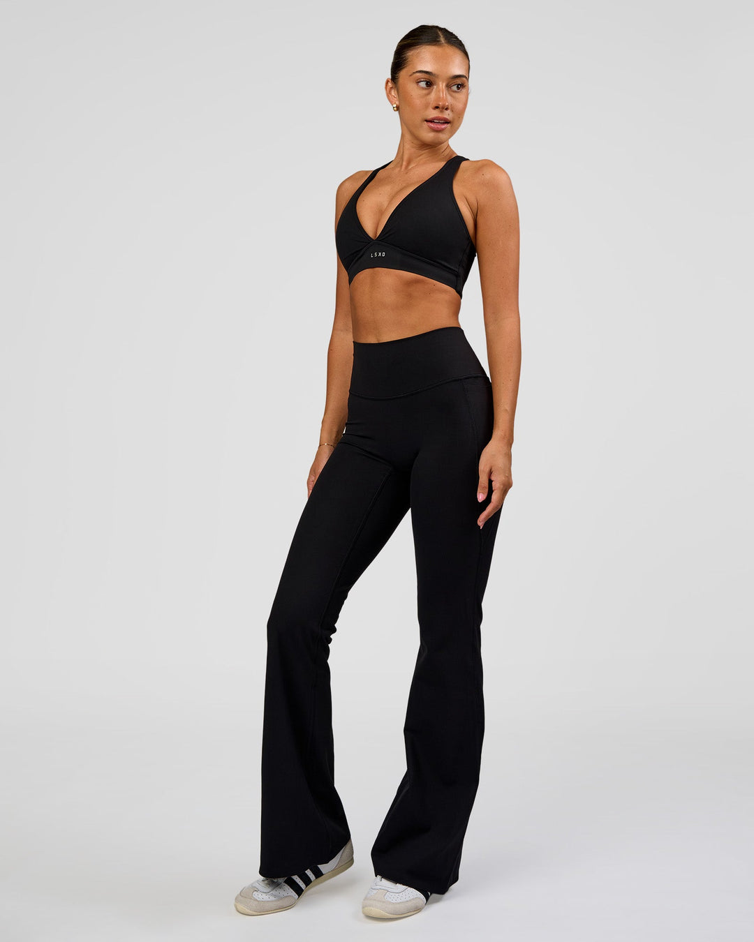 Woman wearing Fusion V-Contour High-Rise Flared Legging Pockets - Black | Model:Charli | Size:XS