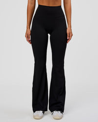 Woman wearing Fusion V-Contour High-Rise Flared Legging Pockets - Black | Model:Charli | Size:XS