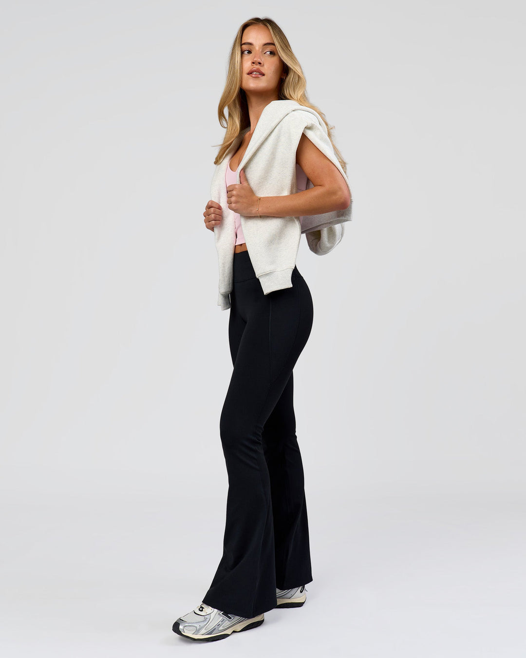 Woman wearing Fusion V-Contour High-Rise Flared Petite Legging Pockets - Black | Model:Issy | Size:XS