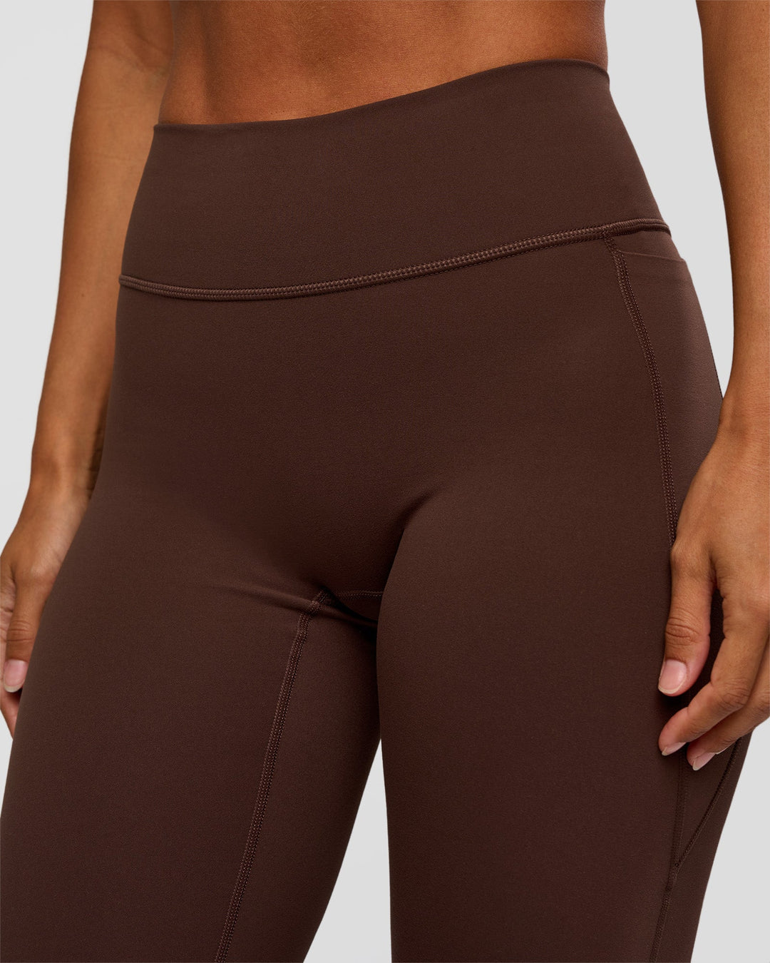 Woman wearing Fusion V-Contour High-Rise Flared Petite Legging Pockets - Hot Chocolate | Model:Brylee | Size:XS