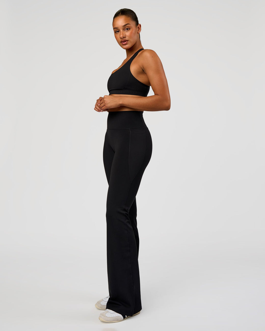 Woman wearing Fusion V-Contour High-Rise Flared Tall Legging Pockets - Black | Model:Rosie | Size:S