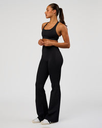 Woman wearing Fusion V-Contour High-Rise Flared Tall Legging Pockets - Black | Model:Rosie | Size:S