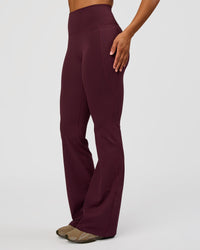 Woman wearing Fusion V-Contour High-Rise Flared Tall Legging Pockets - Cherry Lacquer | Model:Rosie | Size:S