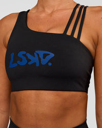 Woman wearing Galvanise Hype Graphic Sports Bra 2.0 - Black-Electric Indigo | Model:Charli | Size:XS