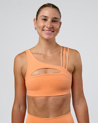 Woman wearing Galvanise Splice Sports Bra - Cantaloupe | Model:Emelia | Size:XS