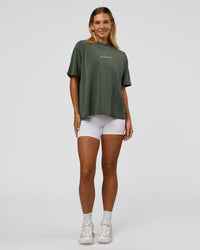 Woman wearing Go-To 1% Better Every Day FLXCotton Oversized Tee - Carbon Green Washed-White | Model:Amity | Size:XS | Thumbnail Index: 1