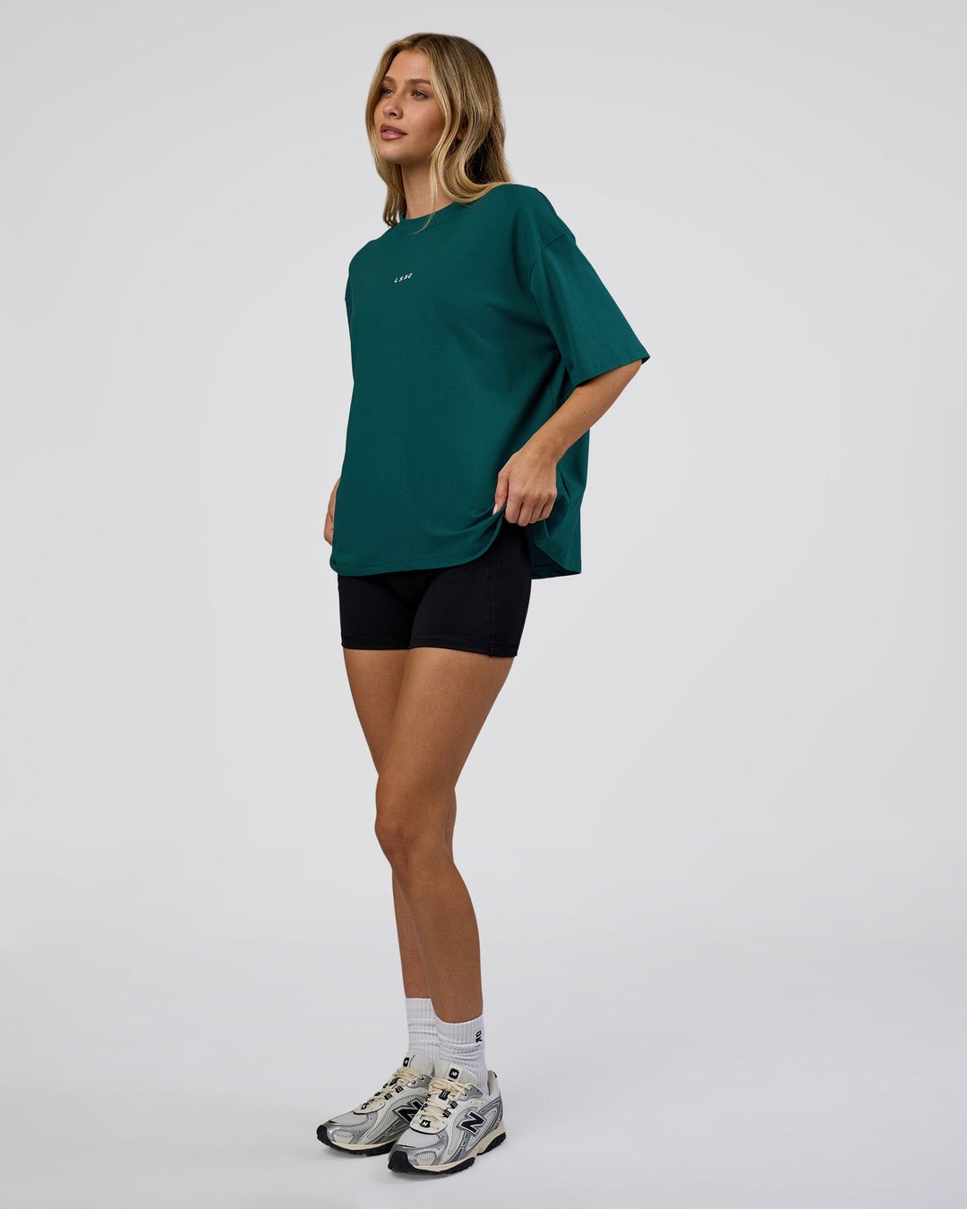 Woman wearing Go-To FLXCotton Oversized Tee - Transformative Teal-White | Model:Leilani | Size:XS