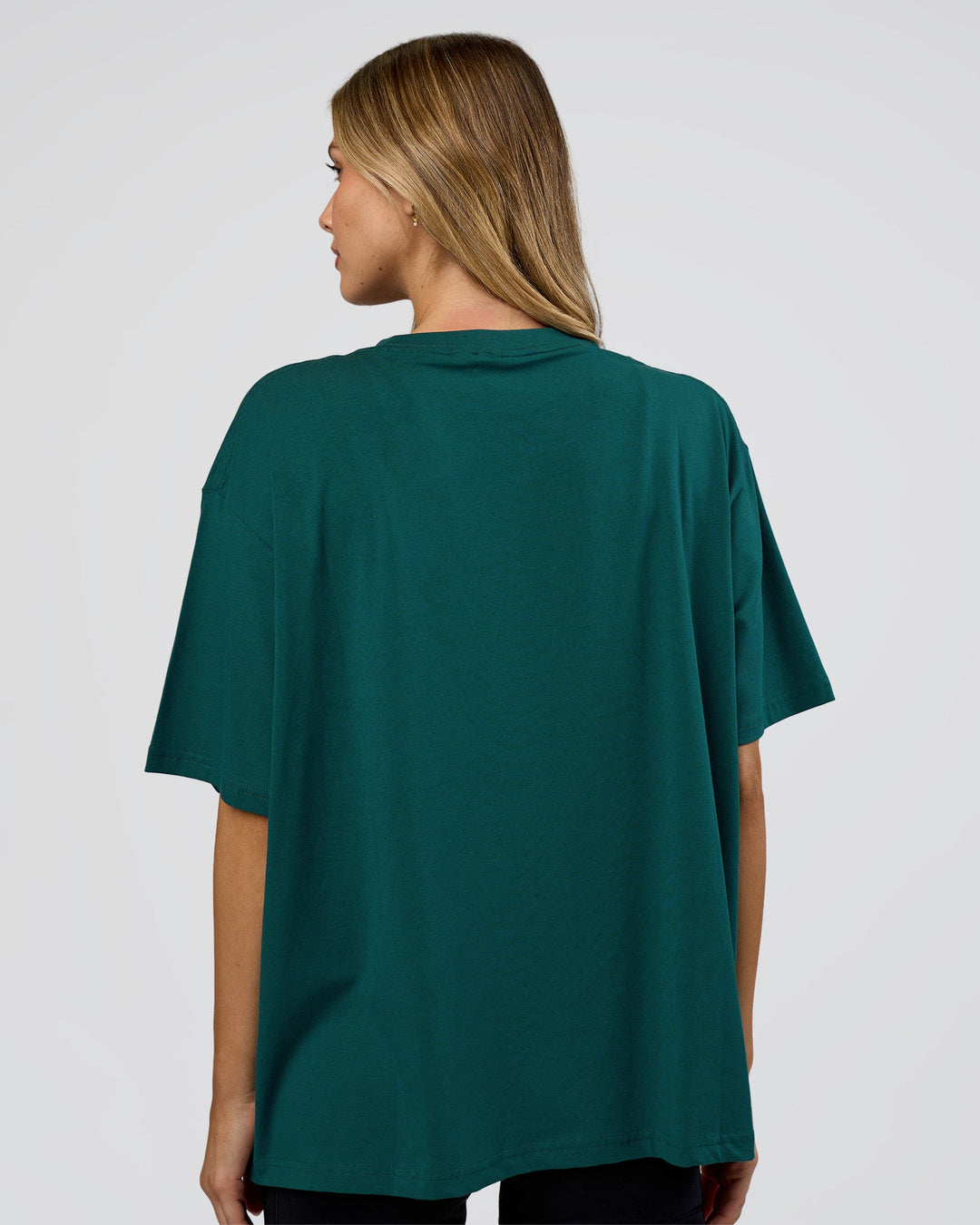 Woman wearing Go-To FLXCotton Oversized Tee - Transformative Teal-White | Model:Leilani | Size:XS