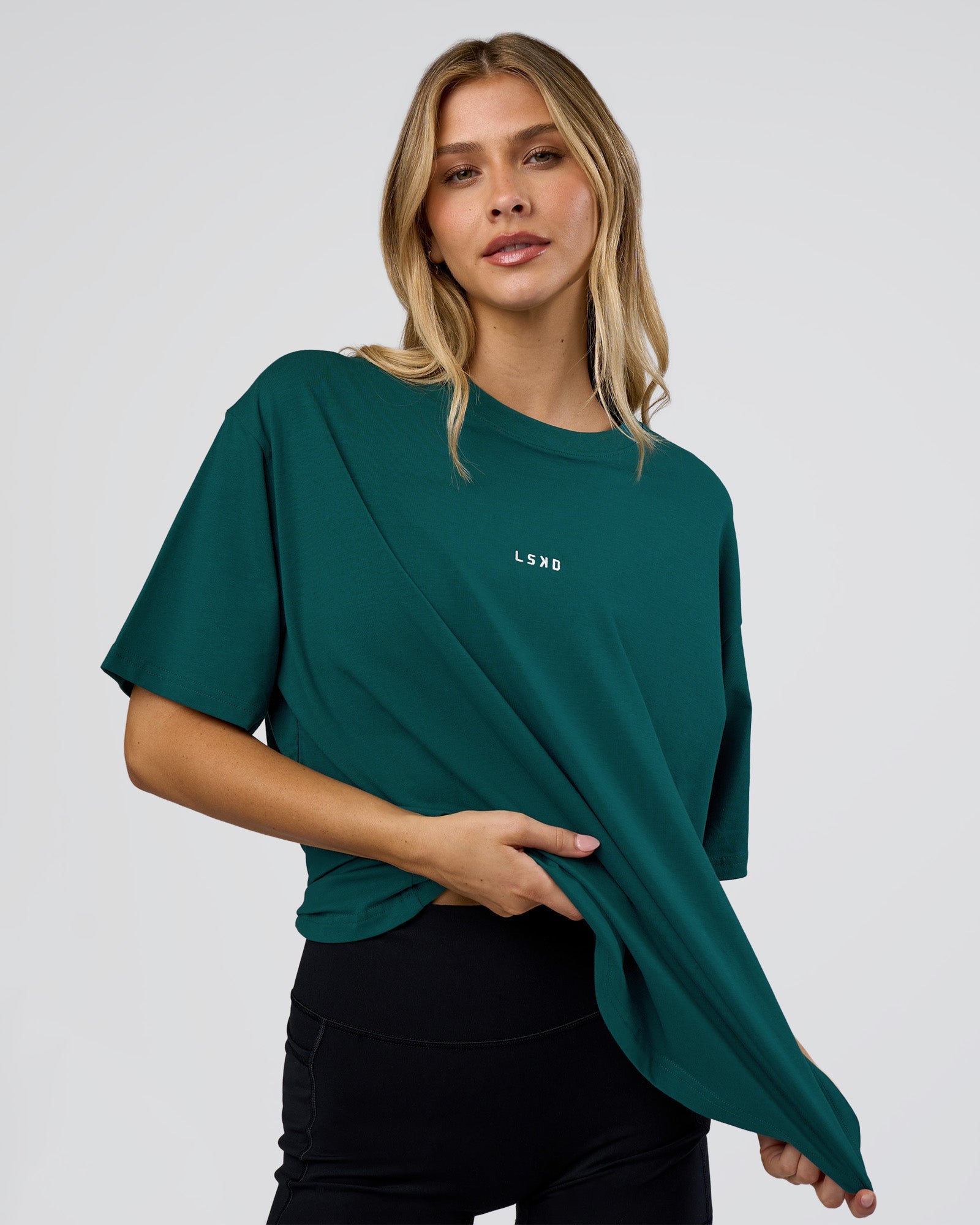 Woman wearing Go-To FLXCotton Oversized Tee - Transformative Teal-White | Model:Leilani | Size:XS