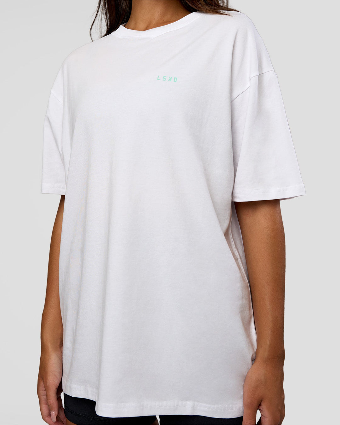 Woman wearing High Run FLXCotton Oversized Tee - White-Jelly Mint | Model:Kirstyn | Size:XS