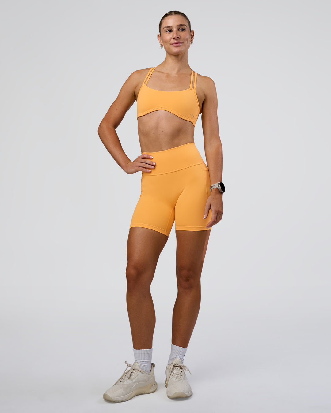 Woman wearing Interstellar Sports Bra - Warm Apricot | Model:Emelia | Size:XS