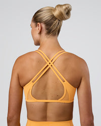 Woman wearing Interstellar Sports Bra - Warm Apricot | Model:Emelia | Size:XS