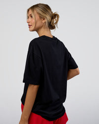 Woman wearing LSKD Run Club FLXCotton Oversized Tee - Black-White | Model:Leilani | Size:XS