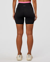 Woman wearing Liberate High-Rise 6" Short Pockets - Black-Candy Pink | Model:Brylee | Size:XS