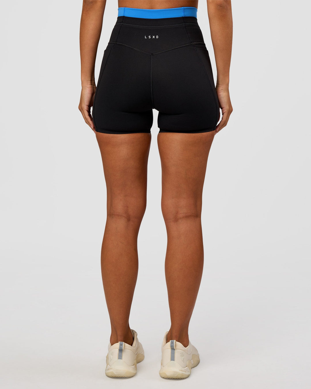 Woman wearing Liberate High-Rise 4" Short Pockets - Black-Palace Blue | Model:Brylee | Size:XS